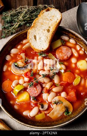 Rustikale Bohnensuppe mit Kartoffeln und Würstchen Stockfoto