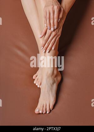 Blick von oben auf die wunderschönen Füße einer Frau mittleren Alters. Konzept der Pflege der Haut der Füße. Stockfoto