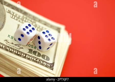 Geld-, Finanz- und Glücksspielkonzept. Nahaufnahme eines amerikanischen Hundert-US-Dollar-Banknotenscheines und zwei weiße Würfel auf der Oberseite, die die Zahlen sechs und sechs zeigen Stockfoto