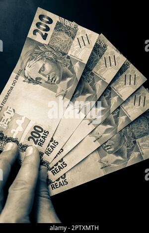 Altes Schwarzweißbild von reich mit Geld in Brasilien. 200 brasilianische Banknoten Reaís Real R$ BRL. Stockfoto