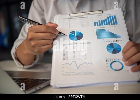 Geschäftsmänner zeigen auf Diagramme und berichten auf Tabellen, Finanzkonten, Marktwirtschaft. Stockfoto