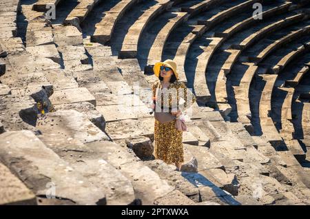 Eine vietnamesische Asiatin besucht das große römische Amphitheater in Side in der Provinz Antalya, Türkei (Turkiye). Das Amphitheater, das bis dato reicht Stockfoto