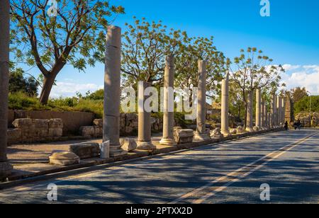 Marmorsäulen aus der Römerzeit säumen eine Straße gegenüber dem Amphitheater in der antiken römischen Stadt Side in der Provinz Antalya, Türkei (Turkiye). Die Stadt lügt Stockfoto