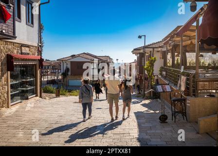 Touristen laufen in der Liman Street in der Altstadt von Side in der Provinz Antalya, Türkei (Turkiye). Side ist der Ort einer antiken römischen Stadt und eine populäre kulturelle und Stockfoto