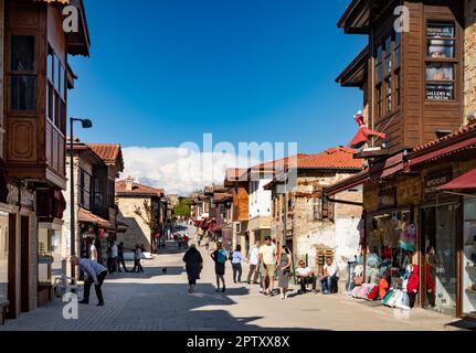 In der Liman Street in der Altstadt von Side in der Provinz Antalya in der Türkei (Turkiye) können sich Touristen durch Geschäfte bummeln und Einheimische unterhalten. Side ist der Ort einer alten römischen Stadt an Stockfoto