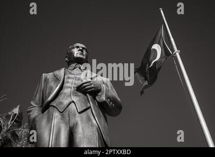 Eine große Bronzestatue von Mustafa Kamal Atatürk, dem Gründer der modernen Türkei, steht neben einem Fahnenmast, der auf einem Platz in Side Ol die türkische Flagge fliegt Stockfoto