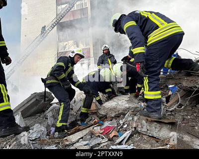 Kiew, Ukraine. 28. April 2023. Rettungskräfte und Einwohner suchen in den Trümmern neben einem beschädigten Wohngebäude in Uman, südlich von Kiew, am Fiday, 28. April 2023 nach Überlebenden, nachdem russische Raketenangriffe über Nacht mehrere ukrainische Städte angegriffen hatten. Bei den größten russischen Luftangriffen seit Monaten in mehreren Städten wurden mindestens 18 Menschen getötet, darunter drei Kinder, sagte der ukrainische Notdienst. Foto: State Emergency Service of Ukraine/UPI. Kredit: UPI/Alamy Live News Stockfoto
