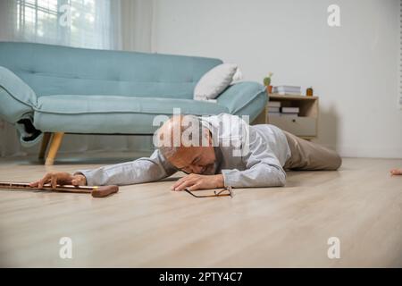 Älterer Senioren Kopfschmerzen, die nach dem Sturz auf dem Boden lagen, Schmerzen und Schmerzen durch Osteoporose, älterer Mann, der allein mit Gehhilfe auf den Boden fällt Stockfoto