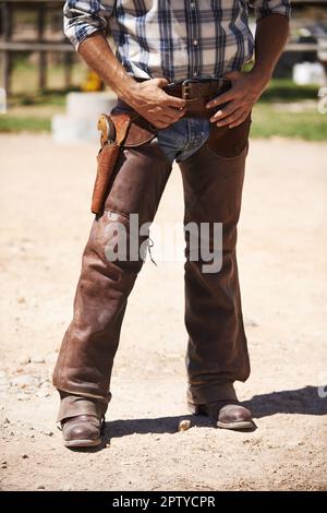 Du willst nicht auf seine schlechte Seite. Ein Cowboy mit der Hand in der Nähe seiner Waffe Stockfoto