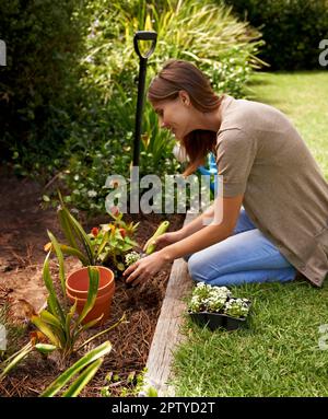 In Kontakt mit ihrem inneren gärtner bleiben. Eine junge Frau im Garten Stockfoto