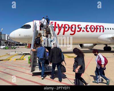 Istanbul, Türkei, 07.21.2022; Passagiere steigen die Rampe zu den Maschinen der Pegasus Airlines hoch. Rückansicht von Personen. Sonniger Tag im Freien. Flypgs.com-Anzeige Stockfoto