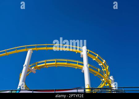 Blick von der gelben Achterbahn vor dem blauen Himmel aus Stockfoto