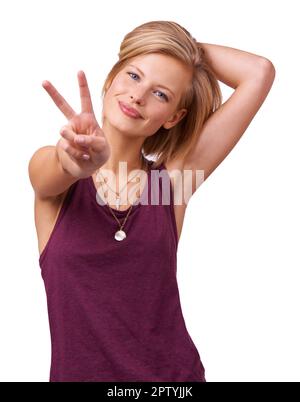 Ruhe jetzt. Studiofoto einer glücklichen jungen Frau, die das Friedenszeichen an die Kamera gibt, isoliert auf Weiß Stockfoto