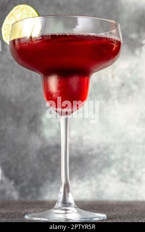 Ein Glas Granatapfel-Margarita-Cocktail auf grauem Hintergrund Stockfoto