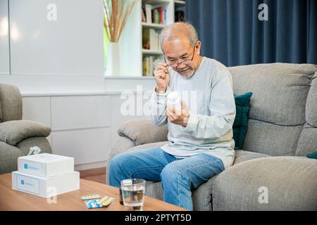 Asiatischer alter Mann kaufen pflanzliche Selbstkur Rx Pille online aus der Apotheke, besorgt Senior Mann mit Medikamenten Pillen, die er auf lesen, wie man Pillen vor der Einnahme zu nehmen Stockfoto