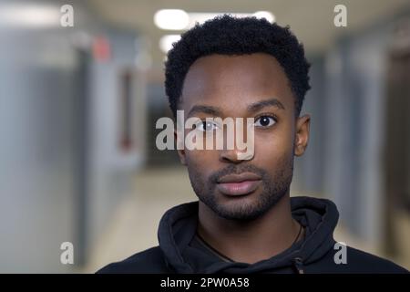 Ein Mann auf dem Universitätskorridor, ein Schüler auf dem Schulcampus, ein kluger Klassenkamerad Stockfoto