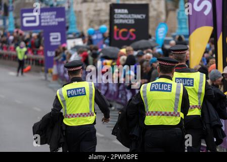 Polizeibeamte treffen ein, um während des TCS London Marathon 2023 eine Gruppe von Just Stop Oil Demonstranten in der Nähe der Tower Bridge zu schützen Stockfoto
