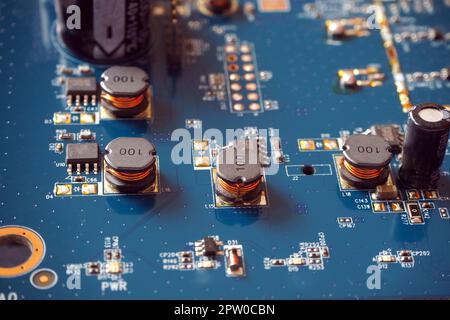 Elektronische Komponenten auf einer Hauptplatine. Spulen, Widerstände und Chips auf der Leiterplatte. Stockfoto