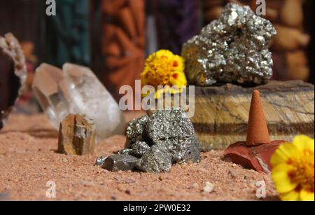 Gelbe Blumen mit Pyritfelsen und Kristallen auf dem australischen roten Sand Stockfoto