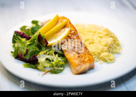 Lachsfilet mit Couscous und Gemüsesalat Stockfoto