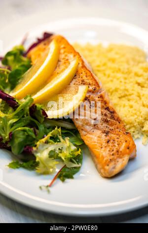 Lachsfilet mit Couscous und Gemüsesalat Stockfoto