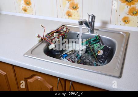 Personal Computer Reinigung metaphorische Konzept. Hardware in der Küche unter Wasser Stockfoto
