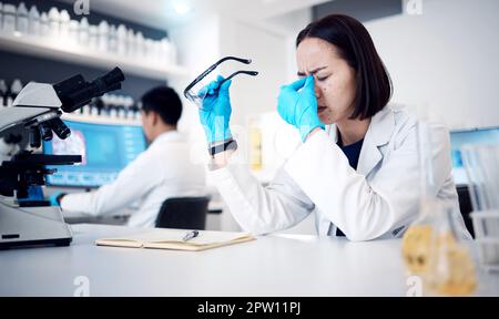 Kopfschmerz, Wissenschaft und Forschung bei einer arbeitenden Frau in einem Labor mit Angstzuständen oder Burnout. Arzt, Stress und Medizin mit einem weiblichen Ischien Stockfoto