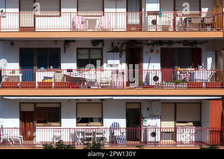 Blick auf die Fassade des Hotels mit Balkonen und Tischen. Stockfoto