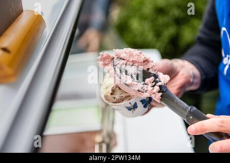 Eiscreme in eine Wanne schöpfen Stockfoto