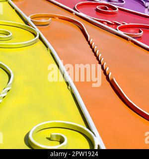 Metall Textur eines Stück farbige Wand mit einem geschmiedeten Muster. Regenbogen Farben Stockfoto