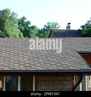 Moderne Bedachung und Dekoration von Schornsteinen. Flexible Bitumen oder Schiefer Schindeln in rechteckiger Form in der Perspektive. Stockfoto