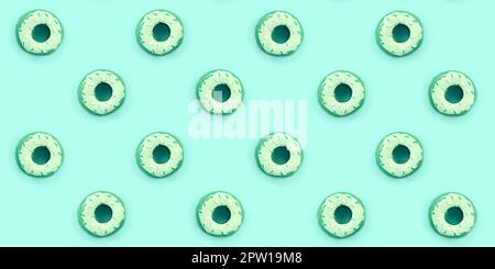 Viele kleine Kunststoff donuts liegt auf einem pastel farbigen Hintergrund. Flach minimal Muster. Ansicht von oben. Stockfoto
