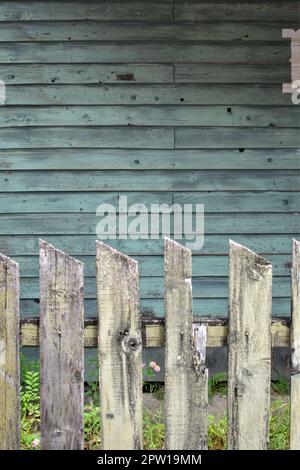 Landgrün verwitterter Hauszaun und Hof Stockfoto