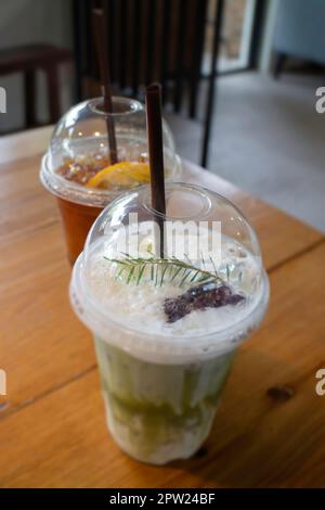 Grüner Eistee mit Milch und Zitronentee auf Holztisch, Stockfoto Stockfoto