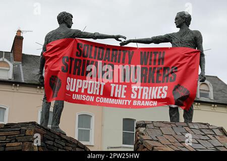 Gewerkschaftsbanner über die Hände über die Skulptur in Derry Stockfoto