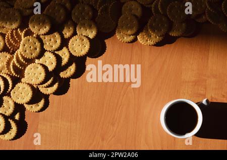 Hintergrund Bild eines kleinen weißen Tasse Kaffee und klassische salzigen Cracker auf einem braunen Holztisch mit Copyspace Stockfoto