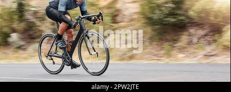 Junger Mann, der seine Radfahrkünste zeigt, während er draußen auf dem Fahrrad unterwegs ist. Adrenalin-Junkie übt ein Speed-Rennen im Freien. Nicht erkennbarer Mann Stockfoto