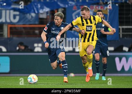 Bochum, Deutschland. 28. April 2023. Fußball: Bundesliga, VfL Bochum - Borussia Dortmund, Matchday 30 im Vonovia Ruhrstadion, Bochums Takuma Asano und Dortmunds Julian Ryerson (r) kämpfen um den Ball. WICHTIGER HINWEIS: Gemäß den Vorschriften der DFL Deutsche Fußball Liga und des DFB Deutscher Fußball-Bund ist es verboten, im Stadion aufgenommene Fotos und/oder das Spiel in Form von Sequenzbildern und/oder videoähnlichen Fotoserien zu verwenden oder verwenden zu lassen. Kredit: Federico Gambarini/dpa/Alamy Live News Stockfoto