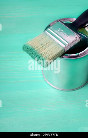 Pinsel mit der grünen Farbe liebt auf der Farbkann Stockfoto