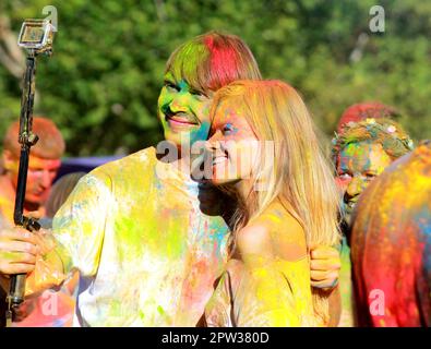 Holi-Festival. Ein Mann und ein Mädchen werden beim Holi Festival in der Stadt Dnipro, Ukraine, 2019-08-28, mit buntem Pulver übergossen Stockfoto