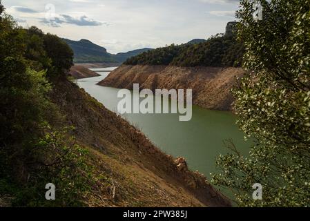 Vilanova de Sau, Spanien - 27. April 2023: Landschaftsblick am Sau-Wasserreservoir. Die Wasserreservoirs, eine der wichtigsten Wasserquellen der spanischen Region Katalonien und insbesondere der Stadt Barcelona, sind nach Angaben der katalanischen Wasserbehörde zu 6 % ausgelastet, während die Wasserreservoirs der Region zu 27 % ausgelastet sind. Die die lokale Regierung gezwungen hat, Maßnahmen gegen die Wasserknappheit zu ergreifen, da Spanien in eine Phase der chronischen Dürre eingetreten ist. Der rekordverdächtige Tiefstand hat die Stadt Sant Romà mit ihrem berühmten Glockenturm, der in den 60s Jahren überflutet wurde, wieder erobert Stockfoto