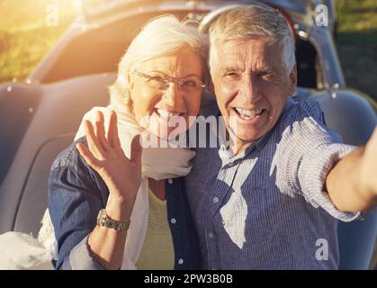 Festhalten von Roadtrips. Ein Seniorenpaar, das ein Selfie macht, während er unterwegs ist Stockfoto