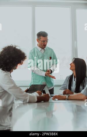 Eine Gruppe von multiethnischen medizinischen Fachkräften, darunter Ärzte, Chirurgen und Krankenschwestern, sind in einem Krankenhaus zusammengekommen, um die Patientenversorgung und zu diskutieren Stockfoto