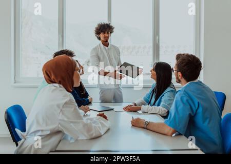 Eine Gruppe von multiethnischen medizinischen Fachkräften, darunter Ärzte, Chirurgen und Krankenschwestern, sind in einem Krankenhaus zusammengekommen, um die Patientenversorgung und zu diskutieren Stockfoto