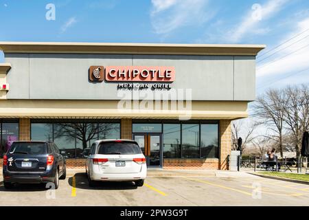 Außenfassade und Eingang des Chipotle Mexican Grill in einer kleinen Einkaufspassage. Zwei Männer essen draußen. Wichita, Kansas, USA. Stockfoto