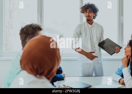 Eine Gruppe von multiethnischen medizinischen Fachkräften, darunter Ärzte, Chirurgen und Krankenschwestern, sind in einem Krankenhaus zusammengekommen, um die Patientenversorgung und zu diskutieren Stockfoto