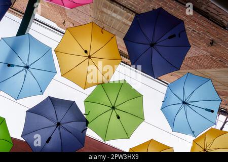 Farbenfrohe Sonnenschirme und rote Backsteinwände im Zentrum von Redlands, Kalifornien Stockfoto