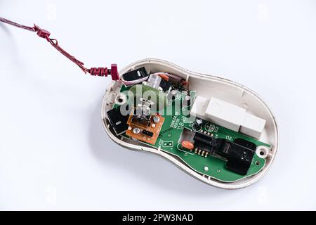 Zerlegte Computermaus auf weißem Hintergrund. Gerätereparatur. Mikrochip in alter Computerhardware. Defekte optische Maus. Speicherplatz kopieren. Stockfoto