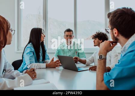 Eine Gruppe von multiethnischen medizinischen Fachkräften, darunter Ärzte, Chirurgen und Krankenschwestern, sind in einem Krankenhaus zusammengekommen, um die Patientenversorgung und zu diskutieren Stockfoto