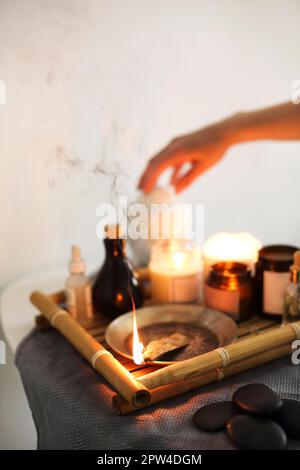 Von oben von Aromatherapie Kerzen und verschiedene Hautpflegeprodukte platziert Auf Holztablett im Spa-Salon Stockfoto